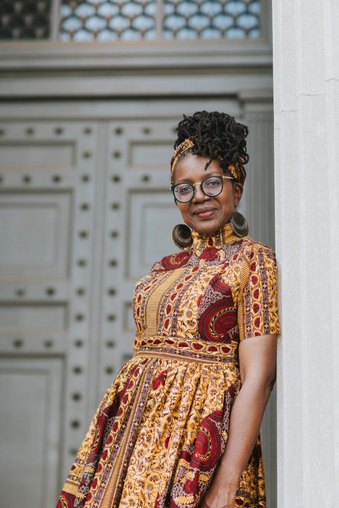 Woman softly smiles in front of the Virginia Museum of History & Culture for a headshot