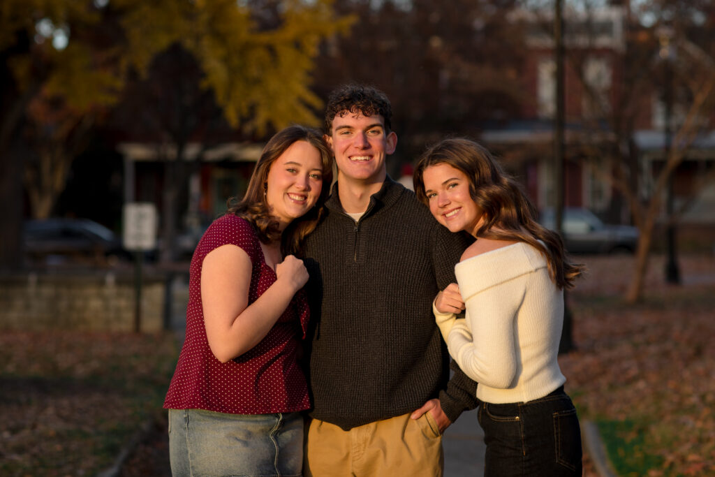 Portrait of triplets hugging at Libby Hill Park during sunset in the fall